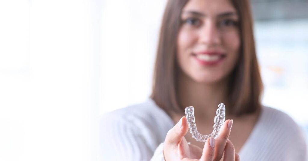 woman holds invisalign